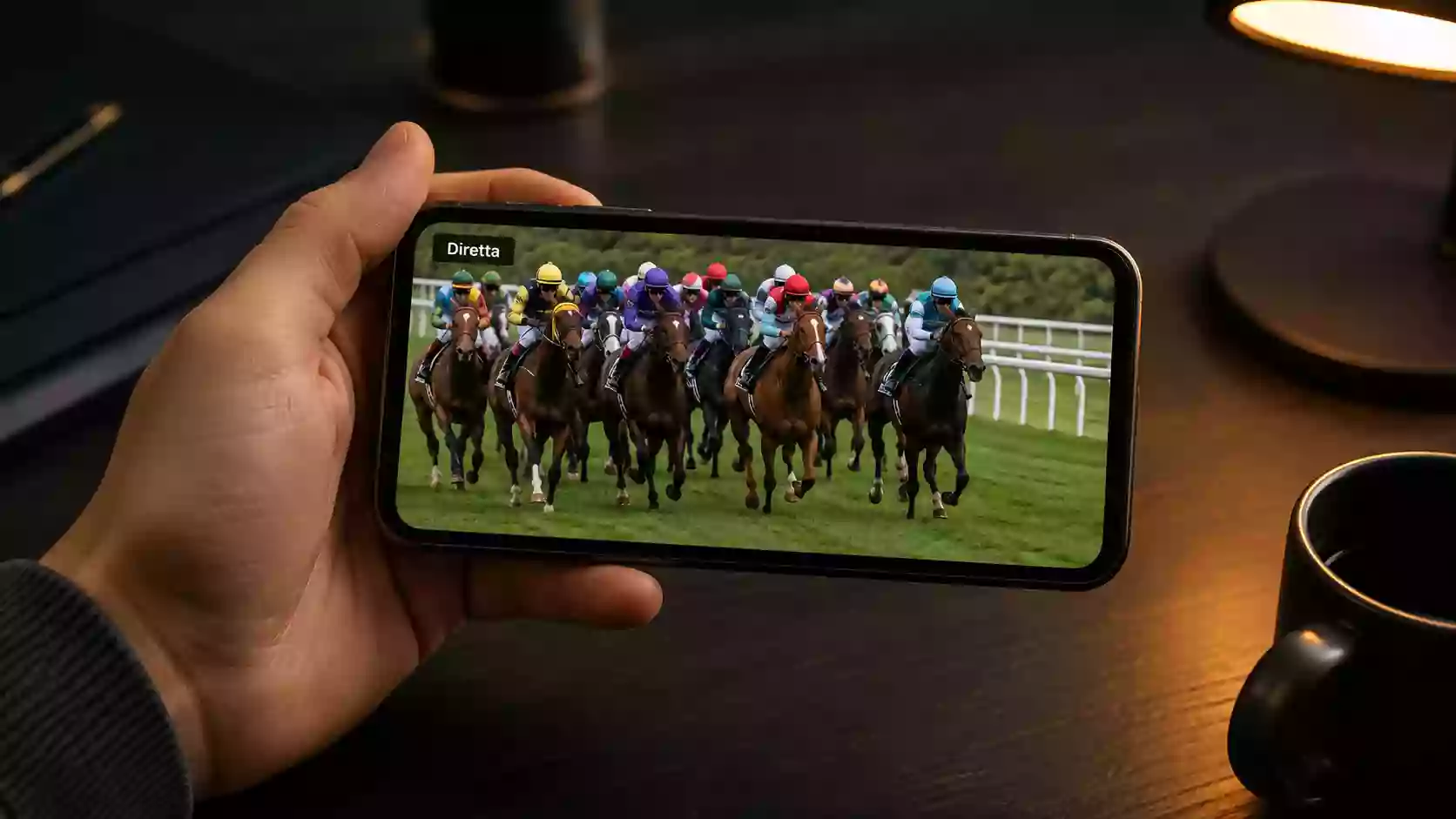 Smartphone con app di scommesse ippiche e streaming di una corsa di galoppo
